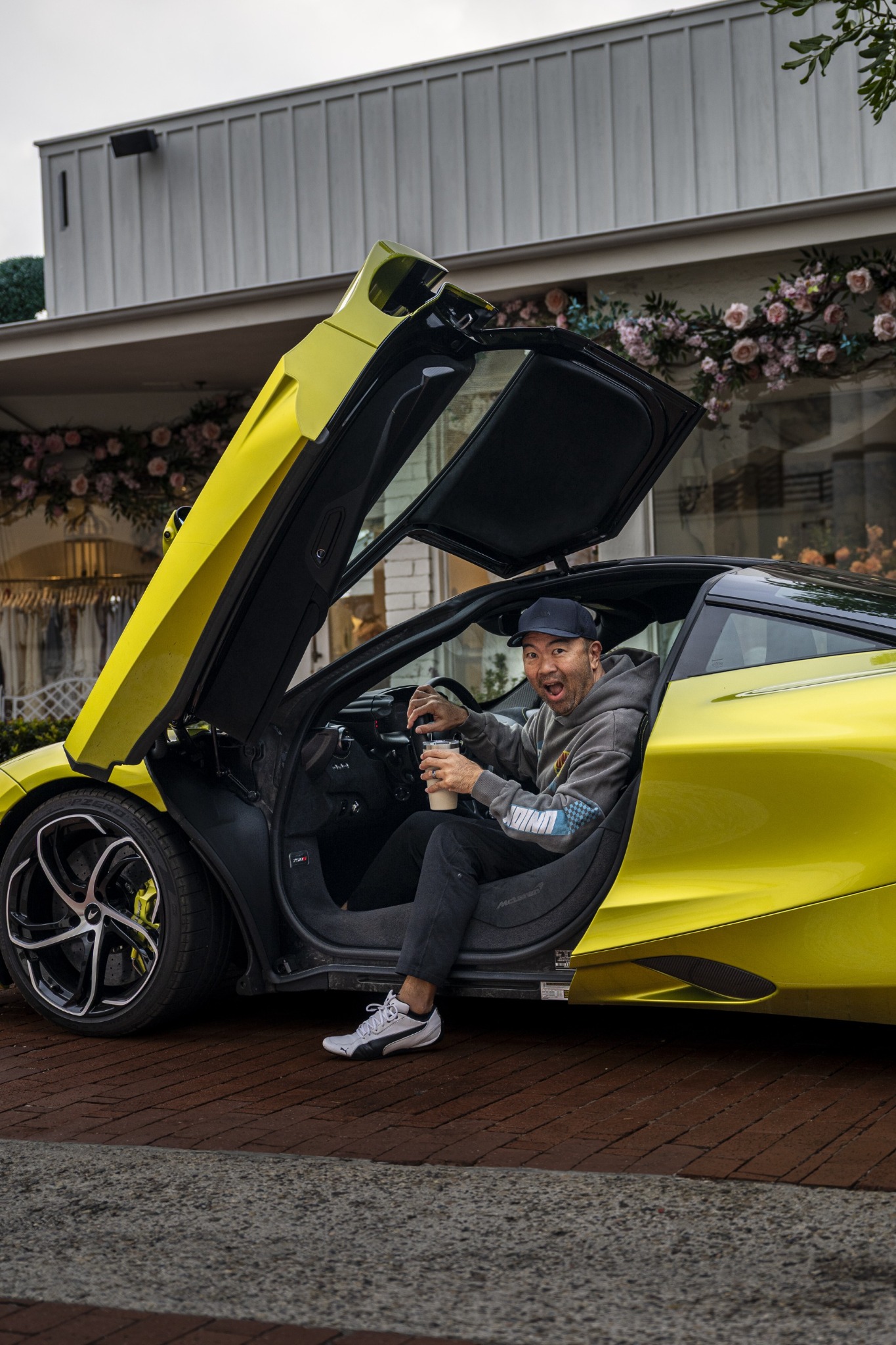 Man seated in a lime green sports car with its door raised